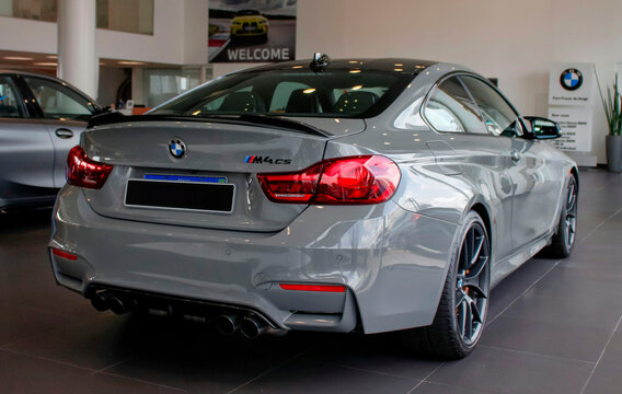 Grey BMW M4 CS F82 in a dealership showroom, German limited edition performance coupe rear quarter view

