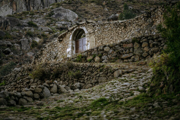 Stone houses with wooden doors and balconies in the traditional village of Tupe, Peru