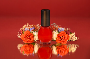 Red nail polish bottle with floral decoration reflection stock photo images. Beautiful nail polish bottle with rose flowers on a red background stock photo. Template for background, banner, card