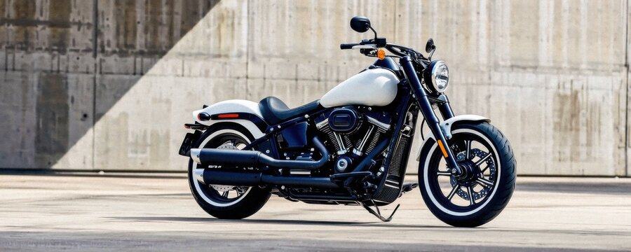 Stylish harley-davidson motorcycle parked against a textured concrete wall, showcasing sleek design and classic features. perfect for automotive enthusiasts.