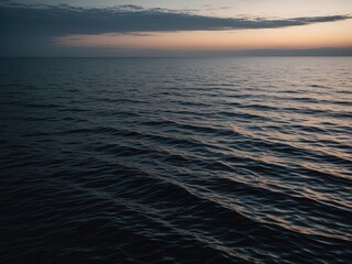 Obraz premium Peaceful ocean at dusk with subtle waves and soft sky color