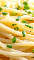 Close-up of cooked spaghetti topped with fresh chives and seasonings