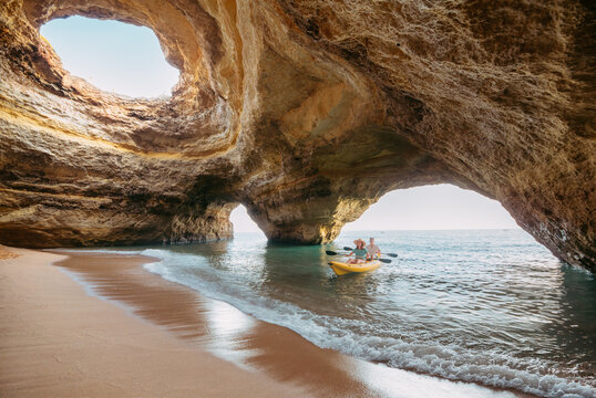 Couple on a kayak exploring the Benagil sea cave in Algarve - Powered by Adobe
