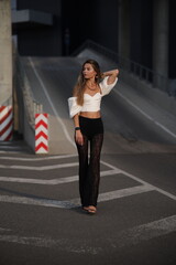 Woman posing on the road wearing fashionable clothes