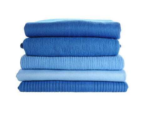 A stack of neatly folded blue textiles in varying shades, against a black background