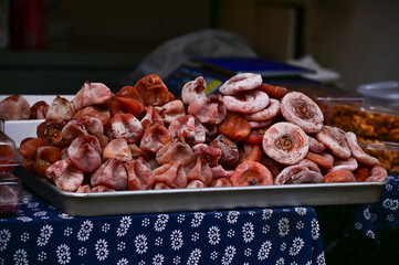 Close-up of dried persimmon, shi in Chinese at a sale market, Fruit market. A very sweet orange tropical fruit. Fruit and food concept.