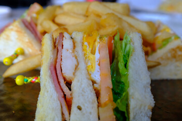 Close-up of the set of Club Sandwich with fries. A western cuisine. A meal for lunch and dinner. Food and beverage concept.