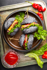 black mini hamburgers, mini burgers in a plate top view