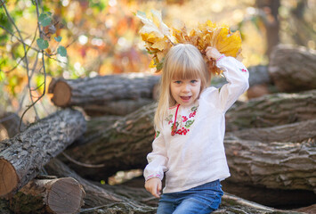 Young Girl Enjoys the Beauty of Autumn by Playing With Colorful Leaves in a Forest While Celebrating Halloween in October