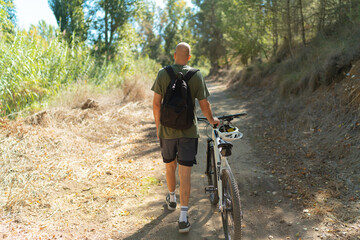 Naklejka premium man riding a bike in forest