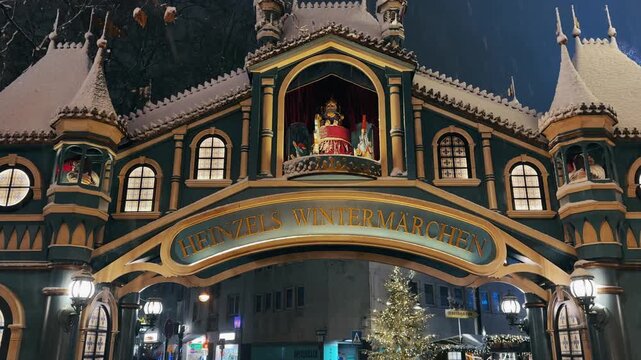 Cologne, Germany - Jan 02, 2024: Cologne Christmas market night scene with havy snow fall and crowd of people at night