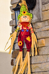 Obraz premium Front view, close distance of, a Halloween straw doll, hanging on stone wall, in overcast lighting