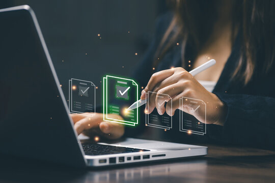 A woman using a stylus pen to select a glowing digital document icon on her laptop, representing online approval, e-signature, workflow automation, and digital document management system.
