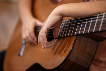 Fototapeta premium Hands playing acoustic guitar strings close up