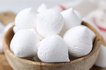 Delicious meringue cookies in bowl on table, closeup