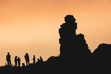 silhouette of a group of people walking in nature. group tourism in the mountains