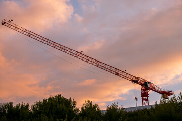 A crane is seen in the sky with a beautiful orange