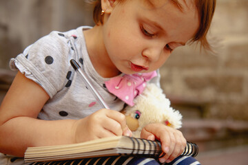 Soft daylight on a child drawing with a toy nearby.