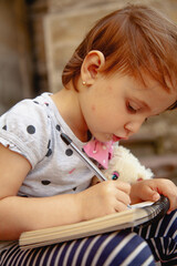 Young child practicing writing with concentration.