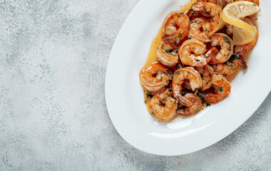 fried tiger prawns, jumbo, in garlic sauce, in butter, with herbs, on a white plate, homemade, no people,