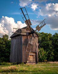 Wooden windmill on a cloudy day in a scenic field
