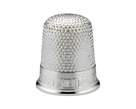 Close-up view of a lustrous silver thimble, adorned with intricate textures and precise detailing