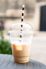 cold latte with ice in a clear glass with a straw