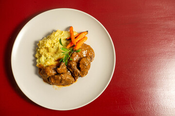 Stewed Iberian pork cheeks with creamy mashed potatoes, a tender and flavorful traditional dish from Spanish and Portuguese cuisine.