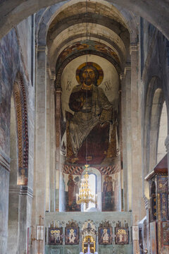 View of a majestic fresco of Jesus Christ watches over the altar, bathed in soft light filtering through ancient arches, Mtskheta, Mtskheta-Mtianeti, Georgia.