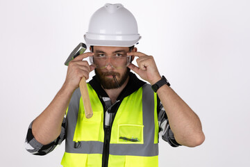 The man in the hard hat is holding a hammer and pointing at his eyes
