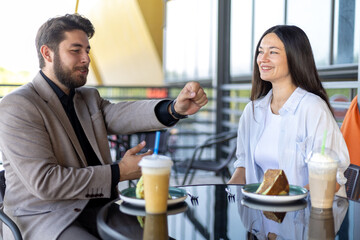 Man and woman dining together at a cozy restaurant table, smiling and engaged