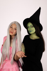 people dressed as witches brewing potions in a spooky forest at night