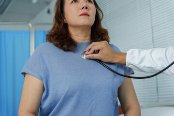 Doctor examining a patient's chest using a stethoscope, checking heart and lung sounds during a routine medical examination
