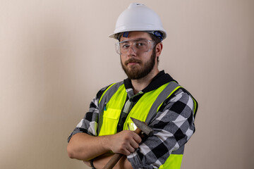 Man in hard hat and safety vest on construction site, inspecting blueprints