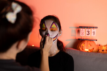 young people are doing makeup for the Halloween holiday.
