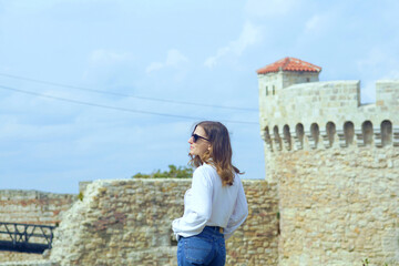 Fototapeta premium Female traveler exploring Kalemegdan Fortress. Symbol of modern sustainable tourism, respect for local culture, preservation of heritage, and mindful exploration of authentic European destinations.