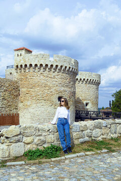 A female tourist admires the architecture of the Belgrade Fortress near the Zindan Gate. Concepts of balanced travel lifestyle, slow exploration habits, and wellness-oriented cultural experiences.