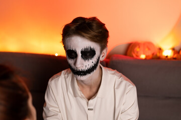 man with skeleton face pain stares intensely,dramatic contrast of dark and light