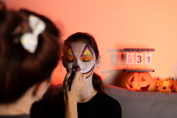 young people are doing makeup for the Halloween holiday.