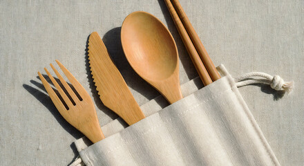 A set of wooden cutlery in a white fabric pouch.