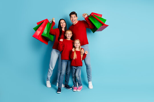 Happy family posing with colorful shopping bags in a festive winter atmosphere, celebrating the holiday season with joy and togetherness.