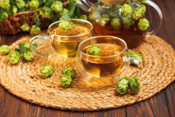 Hop Tea with Fresh Hops in Glass Cups and Teapot on Rustic Background