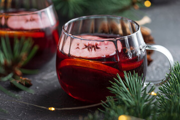 Two Glass Mugs of Mulled Wine with Christmas Decor and Fairy Lights