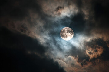 Fototapeta premium Full moon shining through dramatic clouds creating a mystical and atmospheric scene ideal for fantasy or nature-themed projects