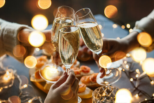 Friends celebrating Christmas or New Year eve party with champagne or sparkling wine. - Powered by Adobe