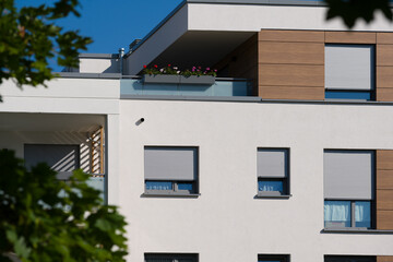 Facade of a modern apartment building with balconies and roller shutters