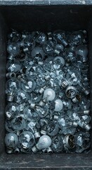 Broken light bulbs piled in a container for disposal and recycling  
