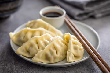 Traditional japanese gyoza dumplings and soy sauce on kitchen table.