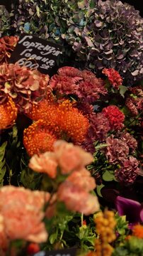 A florist picks a nutan flower to create a bouquet. An atmospheric autumn floral arrangement in warm tones.