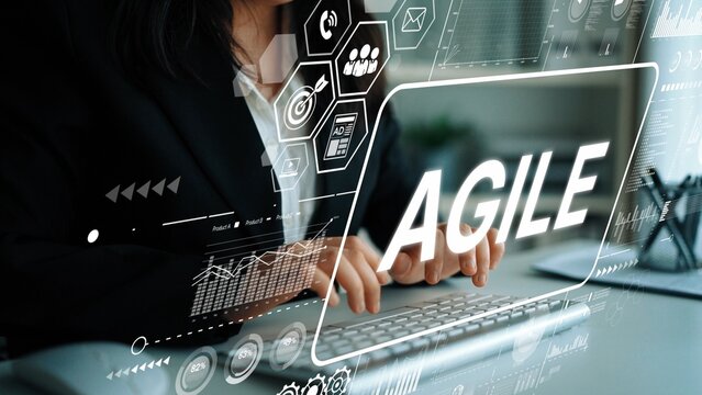 Professional woman typing on a laptop with AGILE text and digital graphics representing modern business concepts and technology. Asymptotic smart data analytic. - Powered by Adobe